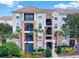 Stunning condo building with balconies and beautiful landscaping including green bushes and palm trees at 8300 Portofino Dr # 403, Davenport, FL 33896