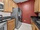 Kitchen area featuring a stainless steel refrigerator, granite countertops, and wood cabinetry at 8300 Portofino Dr # 403, Davenport, FL 33896