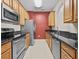 Well-lit kitchen with stainless steel appliances, wood cabinets, and granite countertops at 8300 Portofino Dr # 403, Davenport, FL 33896