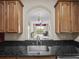 A kitchen view into the living room featuring granite counters and wooden cabinets at 8300 Portofino Dr # 403, Davenport, FL 33896