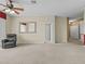 Open living room featuring neutral carpet, ceiling fan, and multiple doorways at 8300 Portofino Dr # 403, Davenport, FL 33896