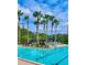 Community swimming pool with lap lanes, lounge chairs and tables, umbrellas, landscaping, and lighting at 8300 Portofino Dr # 403, Davenport, FL 33896