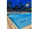 Community swimming pool with lounge chairs, sun umbrellas and covered tables, with lighting for night swims at 8300 Portofino Dr # 403, Davenport, FL 33896