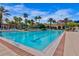 Large community pool features lap lanes, poolside seating, palm trees, and clubhouse in the background at 8300 Portofino Dr # 403, Davenport, FL 33896