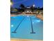Illuminated swimming pool at twilight with palm trees creating a peaceful, resort-style atmosphere for evening relaxation at 8300 Portofino Dr # 403, Davenport, FL 33896