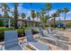 Poolside lounge chairs under palm trees offer a relaxing retreat in a tropical setting at 8300 Portofino Dr # 403, Davenport, FL 33896
