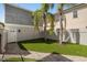 Backyard featuring a green lawn with palm trees and paved walkway to the house at 861 Golden Bear Dr, Reunion, FL 34747