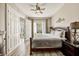 Comfortable bedroom with a ceiling fan, wood-look floors, and large windows offering ample natural light at 861 Golden Bear Dr, Reunion, FL 34747