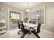 Bright dining room features a modern white table, black chairs, and sliding doors to the outdoor patio at 861 Golden Bear Dr, Reunion, FL 34747