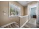 Upstairs hallway area with wood laminate flooring and a large window with view of palm trees at 861 Golden Bear Dr, Reunion, FL 34747