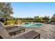 Beautiful backyard showcasing a sparkling pool and spa with lush landscaping and lounge seating at 861 Golden Bear Dr, Reunion, FL 34747