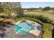 Lush backyard features a sparkling pool, spa, and rock waterfall feature at 861 Golden Bear Dr, Reunion, FL 34747