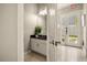 Stylish powder room with a granite countertop, white cabinetry, and a decorative mirror at 861 Golden Bear Dr, Reunion, FL 34747