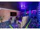Arcade and theater room featuring comfortable reclining chairs, neon lighting, and a cityscape mural at 861 Golden Bear Dr, Reunion, FL 34747