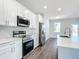 Modern kitchen showcasing stainless appliances, white cabinetry, and an island with a sink at 10 Dogwood Loop Ave, Ocala, FL 34472