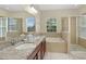 Luxurious bathroom features double sinks, a soaking tub, a glass-enclosed shower, and neutral tile at 1000 Seburn Rd, Apopka, FL 32703