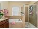 Bathroom featuring a soaking tub with tile surround and a separate glass-enclosed shower for a spa-like experience at 1000 Seburn Rd, Apopka, FL 32703