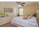 Well-lit bedroom with a ceiling fan, large bed, carpet flooring, and a dresser with decor at 1000 Seburn Rd, Apopka, FL 32703