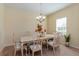 Formal dining room with a chandelier, cream-colored furniture set, and natural light from a window at 1000 Seburn Rd, Apopka, FL 32703