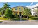 Bright yellow two-story home featuring a well-manicured lawn and mature palm trees at 1000 Seburn Rd, Apopka, FL 32703
