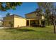 A two car garage is attached to this two story yellow house at 1000 Seburn Rd, Apopka, FL 32703