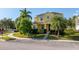 Two-story yellow home with landscaping and palm trees at 1000 Seburn Rd, Apopka, FL 32703