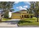 View of a yellow home with a two car garage and screened in back porch at 1000 Seburn Rd, Apopka, FL 32703
