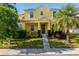 Charming yellow two-story home with a neatly landscaped front yard and concrete walkway at 1000 Seburn Rd, Apopka, FL 32703