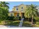 Well-maintained two-story home featuring a vibrant yellow facade and lush landscaping at 1000 Seburn Rd, Apopka, FL 32703