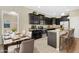 Stylish kitchen featuring dark cabinets, stainless steel appliances, granite countertops, and breakfast bar seating at 1000 Seburn Rd, Apopka, FL 32703