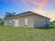 Back exterior view of home with a sliding door, windows, and large yard at 110 Alta Vista Way, Davenport, FL 33837