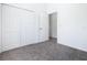 Bright bedroom with neutral carpet, double-door closet, and a view into the next room at 110 Alta Vista Way, Davenport, FL 33837