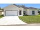 Traditional single-Gathering home with a two-car garage and green lawn at 110 Alta Vista Way, Davenport, FL 33837