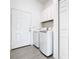 Functional laundry room with washer, dryer, storage cabinets, and exterior door at 110 Alta Vista Way, Davenport, FL 33837