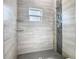 Close up of tiled shower with modern fixtures and glass shelving at 110 Alta Vista Way, Davenport, FL 33837