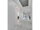 Hallway view featuring marble tile floors, white walls, and tray ceilings at 1130 Pando Loop, Orlando, FL 32824