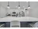 Kitchen island features pendant lighting, sink, and quartz countertops with stainless steel appliances at 1130 Pando Loop, Orlando, FL 32824