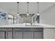 Kitchen island with white countertops, stainless steel sink, and views of the modern living space at 1130 Pando Loop, Orlando, FL 32824