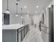 Modern kitchen showcases an island with seating, stainless steel appliances, and marble tile floors at 1130 Pando Loop, Orlando, FL 32824