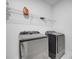 Clean laundry room featuring modern silver washer and dryer units with a shelf above at 1130 Pando Loop, Orlando, FL 32824