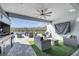 Outdoor living space with comfortable seating area, outdoor kitchen, TV and lake views, perfect for entertaining at 1130 Pando Loop, Orlando, FL 32824