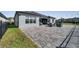 Beautiful home with a large outdoor patio featuring comfortable seating, an outdoor kitchen, and green spaces at 1130 Pando Loop, Orlando, FL 32824