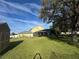 Backyard view with screened in patio, large storage shed, and shady lawn at 1201 Providence Blvd, Kissimmee, FL 34744