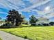 Sprawling front yard featuring a large lawn and mature trees surrounding the home at 1201 Providence Blvd, Kissimmee, FL 34744