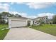 Well-kept single Gathering home with an attached garage and wide driveway surrounded by lush landscaping at 151 Flatfish Ct, Poinciana, FL 34759