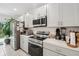 Bright kitchen features stainless steel appliances and grey cabinets at 151 Flatfish Ct, Poinciana, FL 34759