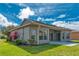 Backyard featuring a covered patio with mature landscaping and green grass at 153 Ventana Dr, Poinciana, FL 34759