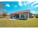 Backyard features a covered patio with seating and a lush green lawn at 153 Ventana Dr, Poinciana, FL 34759