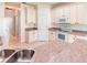 Bright kitchen with a double sink, beige cabinets, and tile flooring, perfect for cooking and entertaining at 153 Ventana Dr, Poinciana, FL 34759