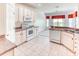 Bright kitchen with white appliances and cabinetry, tile floors, and adjacent dining area at 153 Ventana Dr, Poinciana, FL 34759